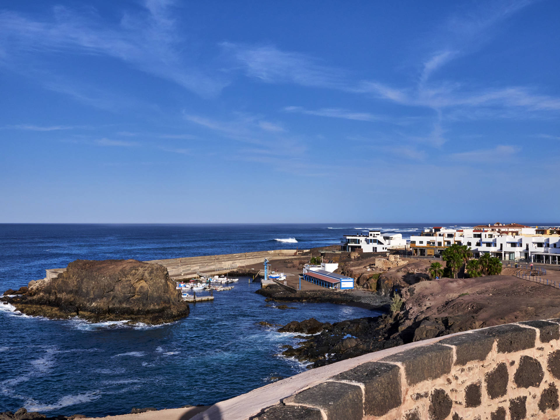 Blick vom Castillo de Rico Roque o Torre de El Tostón auf den Roca de la Mar, den Hafen und El Cotillo.